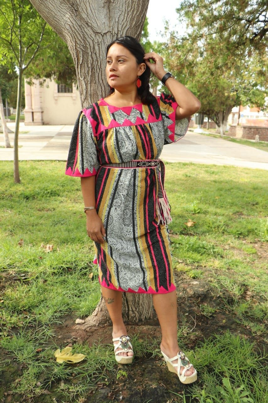 Mujer modelando un vestido de Bikiyá Sopory con estampado vertical y aplicaciones geométricas rosas y negras.